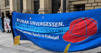 Kundgebung vor dem Abgeordnetenhaus Berlin. Zu sehen ist ein blaues Banner mit der Aufschrift: "Burak unvergessen. Aufklären & Gedenken! Burak´ı unutma. Hatırla ve Aydınlat!" Auf dem Banner ist eine stilisierte rote Kappe dargestellt.